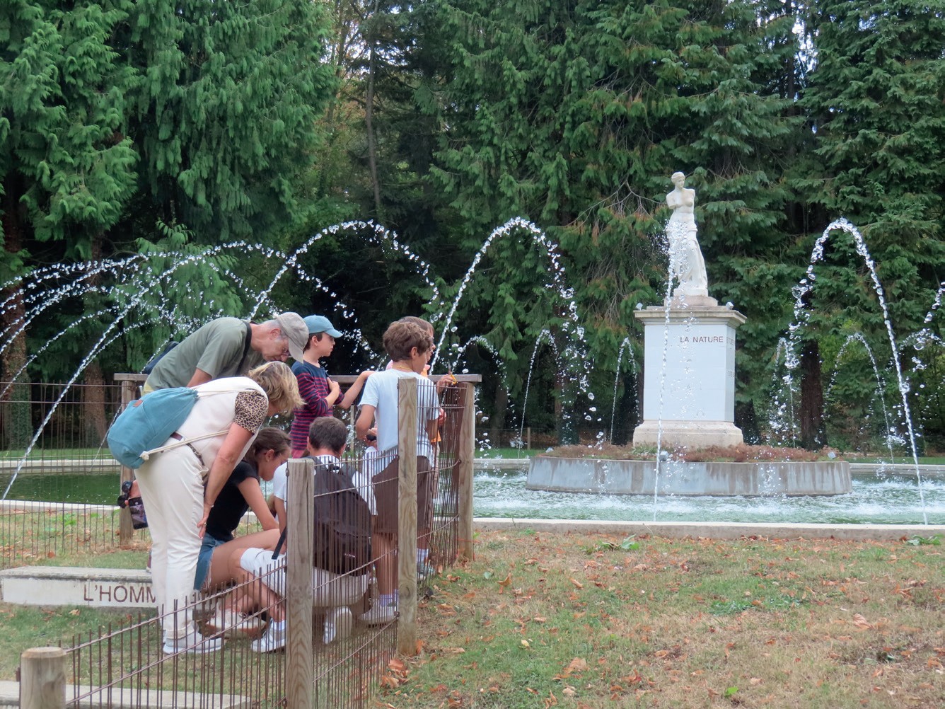 Un groupe de personnes près de la fontaine avec la statue de Diane